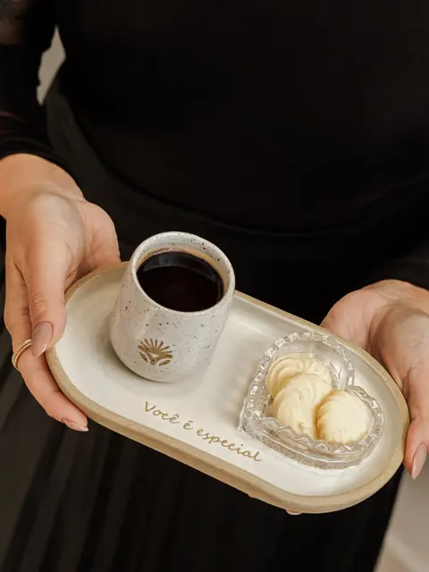 Mãos segurando uma bandeja com café e docinhos, com a frase Você é especial